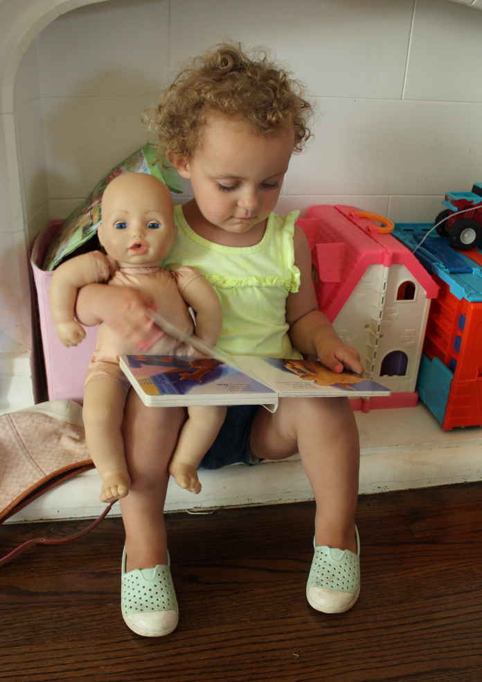 C reading with baby doll