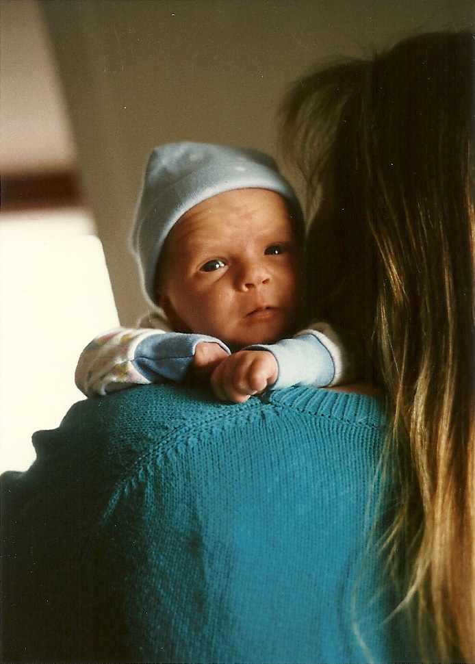 Baby face over mother's shoulder.